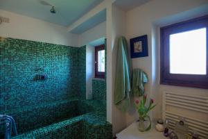 a bathroom with a green tiled shower and a tub at Villa delle Croci in Scandicci +15 photos