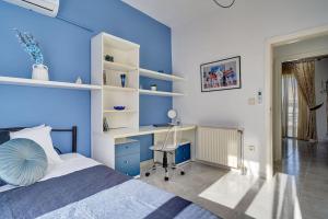 a blue bedroom with a bed and a desk at Chrysanthi Luxury Villa In Salakos, with Pool & Jacuzzi, Near Beach in Sálakos +40 photos