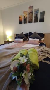 Una cama con mantas verdes y flores. en Limonádé Apartman, en Gárdony