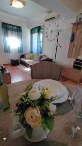 a table with a vase with flowers on it at Limonádé Apartman in Gárdony