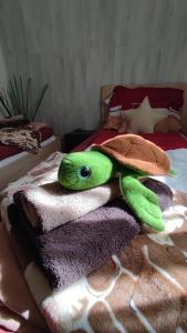 a stuffed turtle laying on top of towels on a bed at Limonádé Apartman in Gárdony