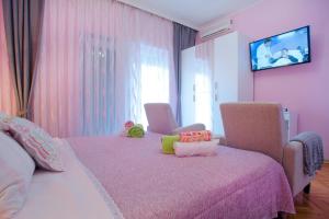 a pink bedroom with a bed and a tv on the wall at Ferienwohnung für 2 Personen ca 32 qm in Milčetići, Kvarner Bucht Krk - b58170 in Malinska