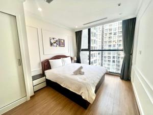 Un dormitorio con una cama y una ventana grande. en Nanahousing-3 Bedroom Apartment Vinhomes Skylake, en Hanói