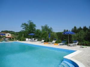 una gran piscina con sombrillas y sillas azules en Ferienwohnung für 8 Personen ca 170 qm in Fauglia, Toskana Etruskische Küste, en Fauglia