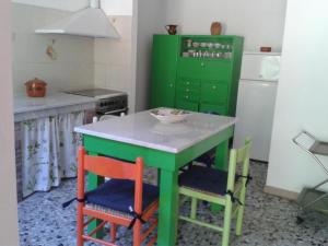 una cocina con una isla verde con 4 sillas en Ferienwohnung für 8 Personen ca 170 qm in Fauglia, Toskana Etruskische Küste, en Fauglia