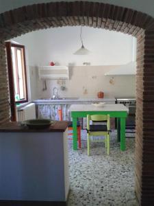 cocina con mesa verde en una habitación en Ferienwohnung für 8 Personen ca 170 qm in Fauglia, Toskana Etruskische Küste, en Fauglia