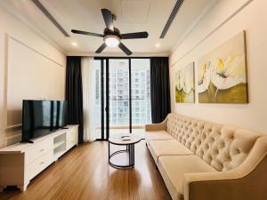 Una sala de estar con un sofá y un televisor de pantalla plana. en Nanahousing-3 Bedroom Apartment Vinhomes Skylake, en Hanói