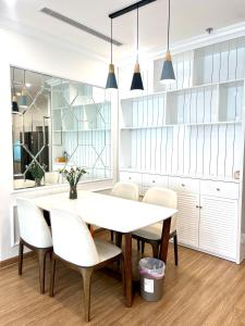 Un comedor con una mesa y sillas blancas. en Nanahousing-3 Bedroom Apartment Vinhomes Skylake, en Hanói
