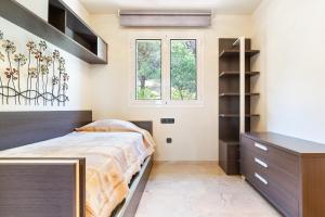 1 dormitorio con 1 cama y vestidor en CASA ADOSADA WELCS 137 con piscina comunitaria, en Sant Feliu de Guíxols