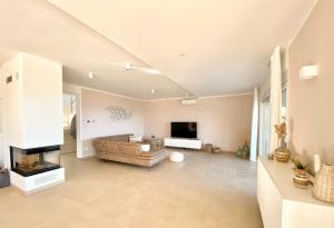 ein Wohnzimmer mit einem Sofa und einem TV in der Unterkunft Villa Maritima-Meerblick-Infinity Pool-Luxus-Relax in Poljane
