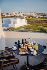 - une table avec un plateau de nourriture sur le balcon dans l'établissement Bonsai Luxury Suites, à Karterados