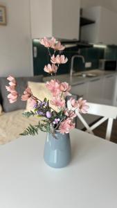 een vaas gevuld met roze bloemen op een tafel bij TRIO apartment in Piešťany