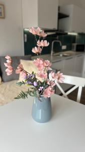 a vase filled with pink flowers on a table at TRIO apartment in Piešťany +15 photos