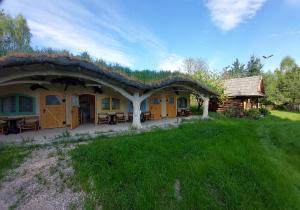 a house with a thatched roof and a yard at Stary Spichlerz nad Wartą in Osjaków