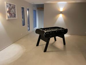 Un piano negro en una habitación con luz. en Villa Ioda, en Chasseneuil-du-Poitou