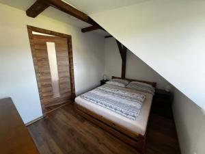 a small bedroom with a bed in a attic at apartmán Crystalindo in Smržovka