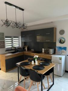 a kitchen with a table and chairs in a kitchen at Domek Pod Gwiazdami Bieszczady in Hużele