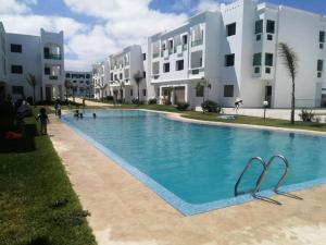 een groot zwembad voor sommige gebouwen bij Cozy appartement à Mansouria res fermé 4 piscines in Mansouria