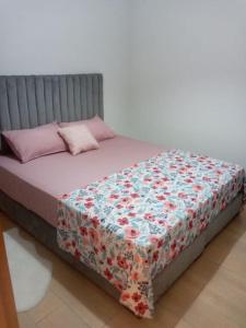 een bed met een bloemendeken erop bij Cozy appartement à Mansouria res fermé 4 piscines in Mansouria