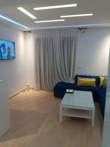een woonkamer met een blauwe bank en een tafel bij Cozy appartement à Mansouria res fermé 4 piscines in Mansouria