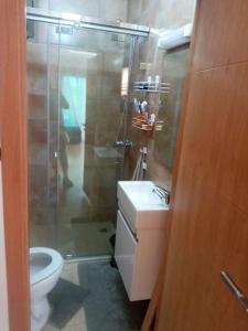 een badkamer met een douche, een toilet en een wastafel bij Cozy appartement à Mansouria res fermé 4 piscines in Mansouria