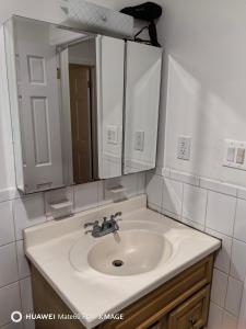 een badkamer met een witte wastafel en een spiegel bij 如家 in Bayside