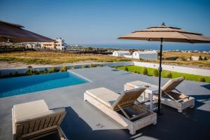 a patio with two chairs and an umbrella at Bonsai Luxury Suites in Karterados