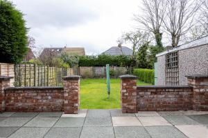 a brick fence with a gate in a yard at AvenueHouse-BusinessReady-FREEParking&WIFI in Baguley