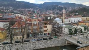 Blick auf eine Stadt mit einer Brücke und Gebäuden in der Unterkunft Waterfall Hostel in Sarajevo