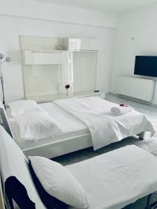 - une chambre blanche avec 2 lits dans l'établissement Apart Studio Maria - Parcare Privata, à Bucarest
