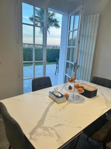 una mesa con naranjas en una habitación con ventana en Maisons d'hôte à la campagne Parisienne en Longjumeau