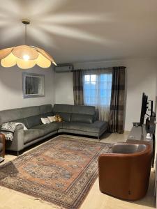 a living room with a couch and a rug at Maisons d'hôte à la campagne Parisienne in Longjumeau