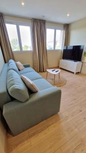 uma sala de estar com um sofá e uma televisão em Appartement 2 chambres et balnéo proximité Dunkerque em Dunkerque