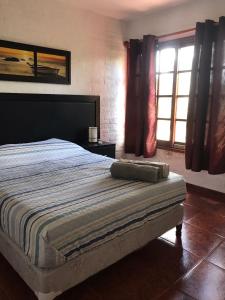 a bedroom with a large bed and a window at Roca de Guía. Casa con piscina y barbacoa cerca del mar in Punta del Este