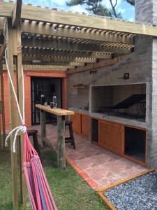 a patio with a table and an outdoor kitchen at Roca de Guía. Casa con piscina y barbacoa cerca del mar in Punta del Este