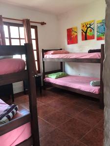 a room with three bunk beds and a window at Roca de Guía. Casa con piscina y barbacoa cerca del mar in Punta del Este