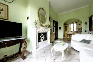 sala de estar con sofá blanco y chimenea en Hostly-Garden House Metato-Apartment with Garden, 15min from sea, en Fiocina