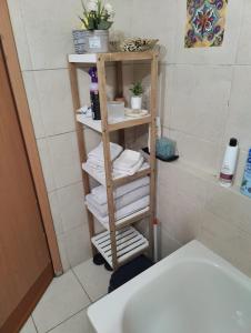 a bathroom with a wooden towel rack with towels at Ashkelon a front of the sea in Ashqelon