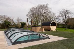 una pequeña piscina en un patio con un edificio en Vakantiewoning L'Eau Tendre in Ellezelles, met wellness, buitenzwembad en paardenstalling en Ellezelles