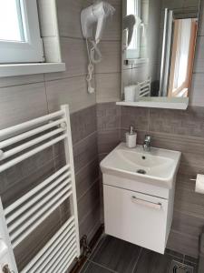 een badkamer met een witte wastafel en een spiegel bij Sobe Sara in Šabac