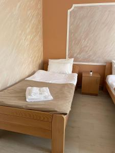 a bedroom with a bed with a white blanket on it at Sobe Sara in Šabac
