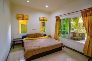 a bedroom with a bed and a large window at Little Yellow House - AoNang in Ao Nang Beach