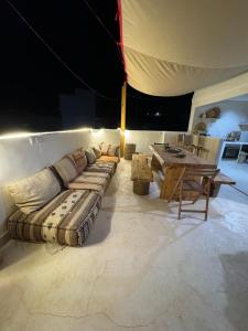 uma sala de estar com um sofá e uma mesa em Tazuri Surf House em Taghazout
