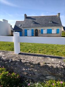 une clôture blanche devant une maison dans l'établissement Trouz Ar Mor, à Penmarcʼh