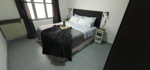 a bedroom with a bed with a black blanket on it at Centrico y Luminoso: Tu Refugio en Rio Gallegos in Río Gallegos