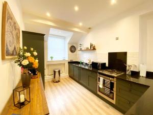 a kitchen with green cabinets and a counter top at Ferienwohnung für 4 Personen ca 80 qm in Torquay, England Südküste von England in Torquay