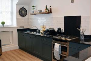 una cucina con piano di lavoro nero e piano cottura di Ferienwohnung für 4 Personen ca 80 qm in Torquay, England Südküste von England a Torquay