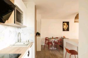 a kitchen and dining room with a table and chairs at Le Candle - Parking & Balcon - Muret - Toulouse in Muret