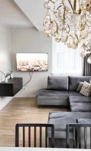 a living room with a couch and a chandelier at Saulene Apartments in Palanga