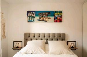 a bedroom with a bed with two paintings on the wall at Le Candle - Parking & Balcon - Muret - Toulouse in Muret